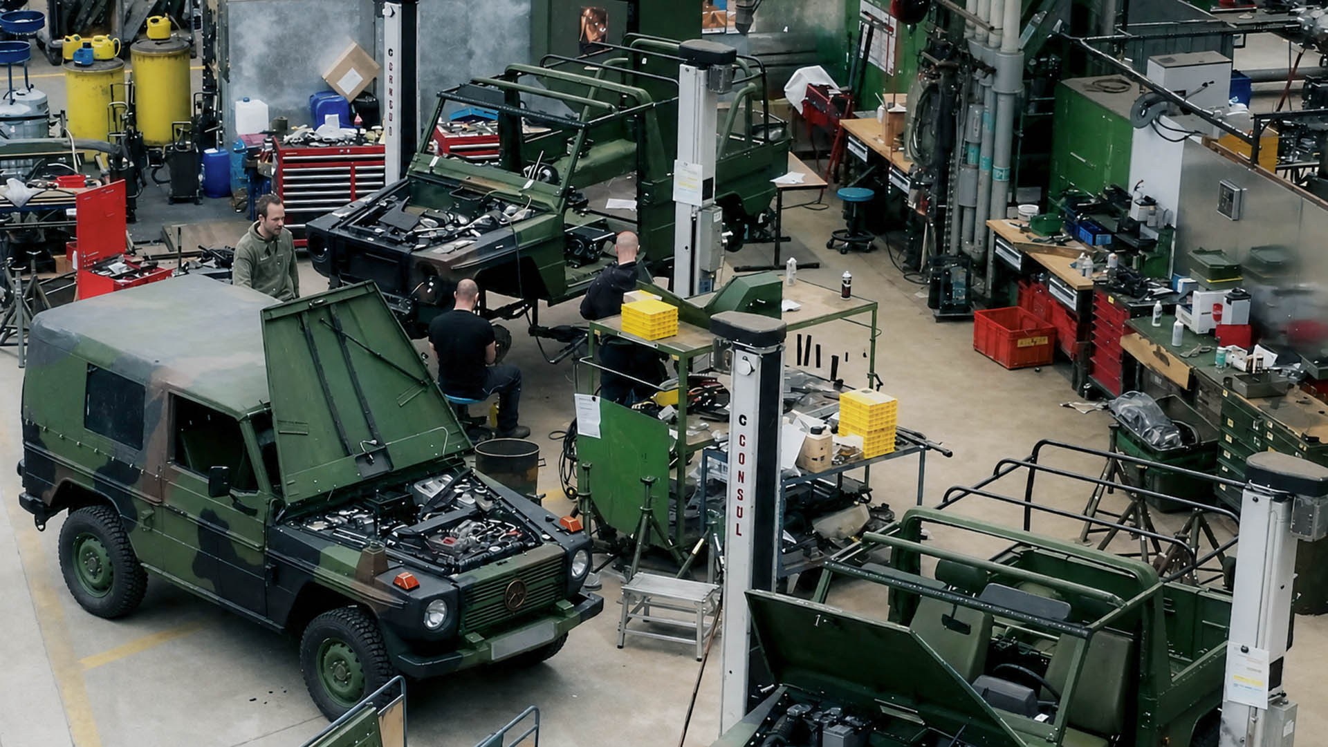 Werkhalle mit mehreren Militärfahrzeugen im Montageprozess