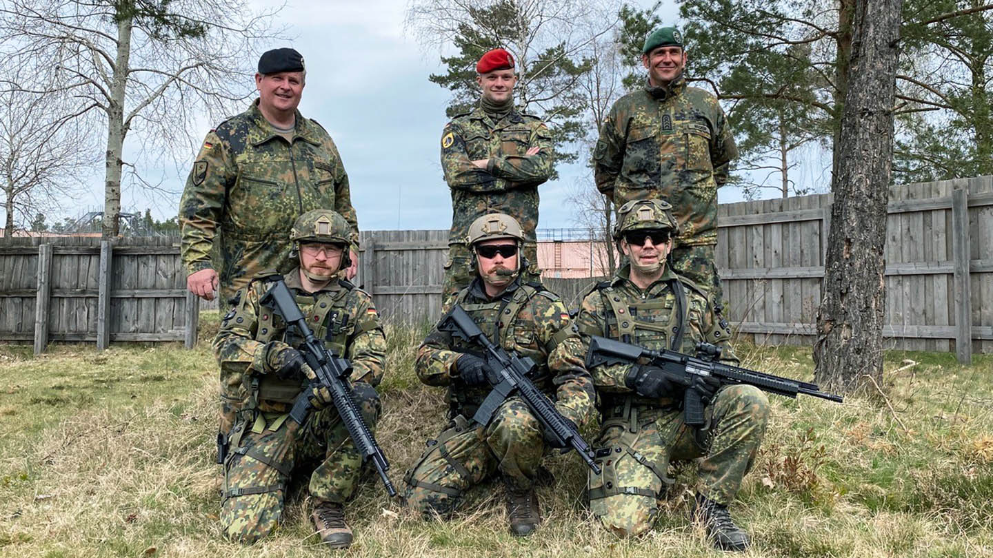 Gruppe von Soldaten posiert mit Ausrüstung im Freien