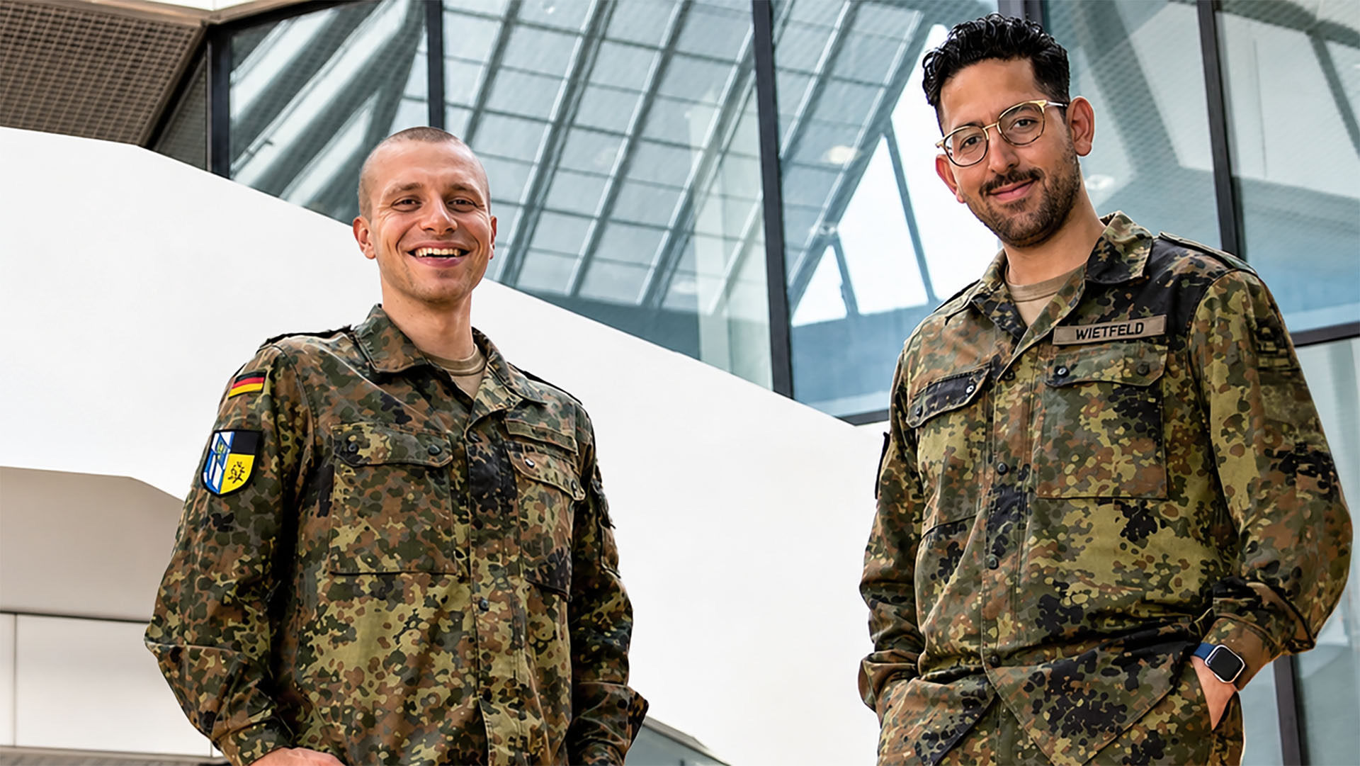 Leutnant zur See Florian Roth und Oberleutnant Marc Wietfeld stehen in Uniform in modernem Innenraum