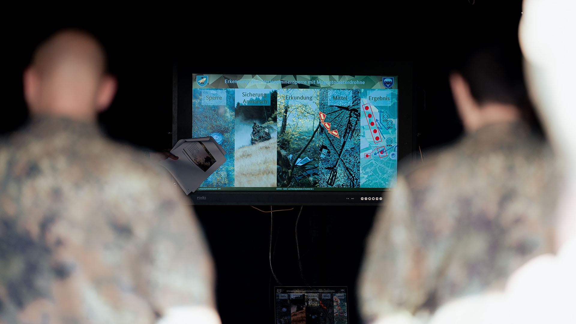 Zwei Personen betrachten Analysefolie auf Monitor im Innenraum
