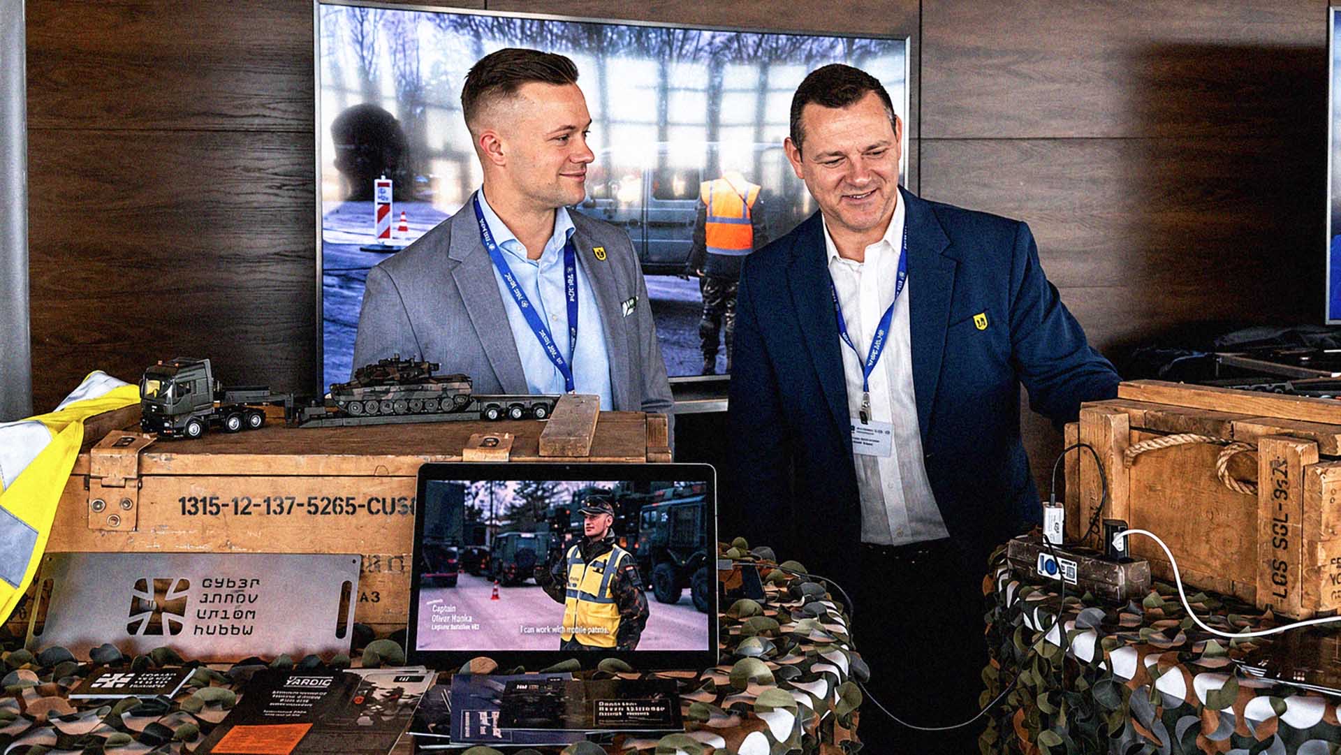 Zwei Personen präsentieren Ausrüstung und Modelle an Messestand