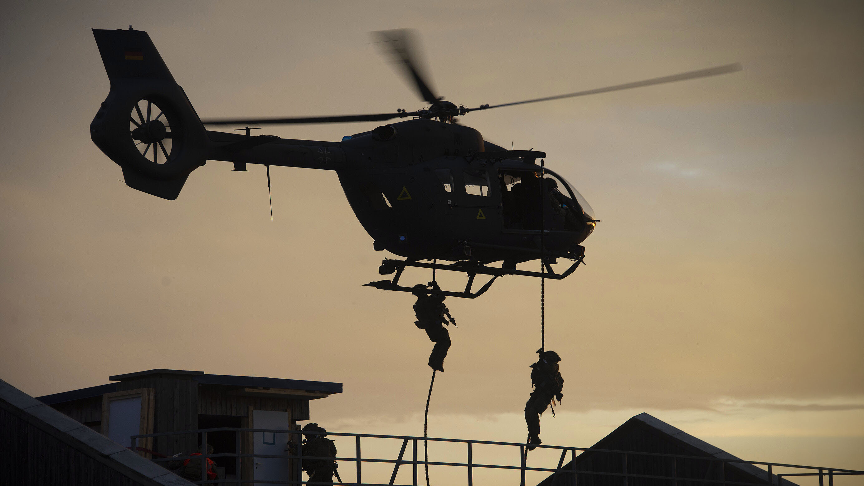 Hubschrauber setzt zwei Soldaten per Seil auf Gebäudedach ab