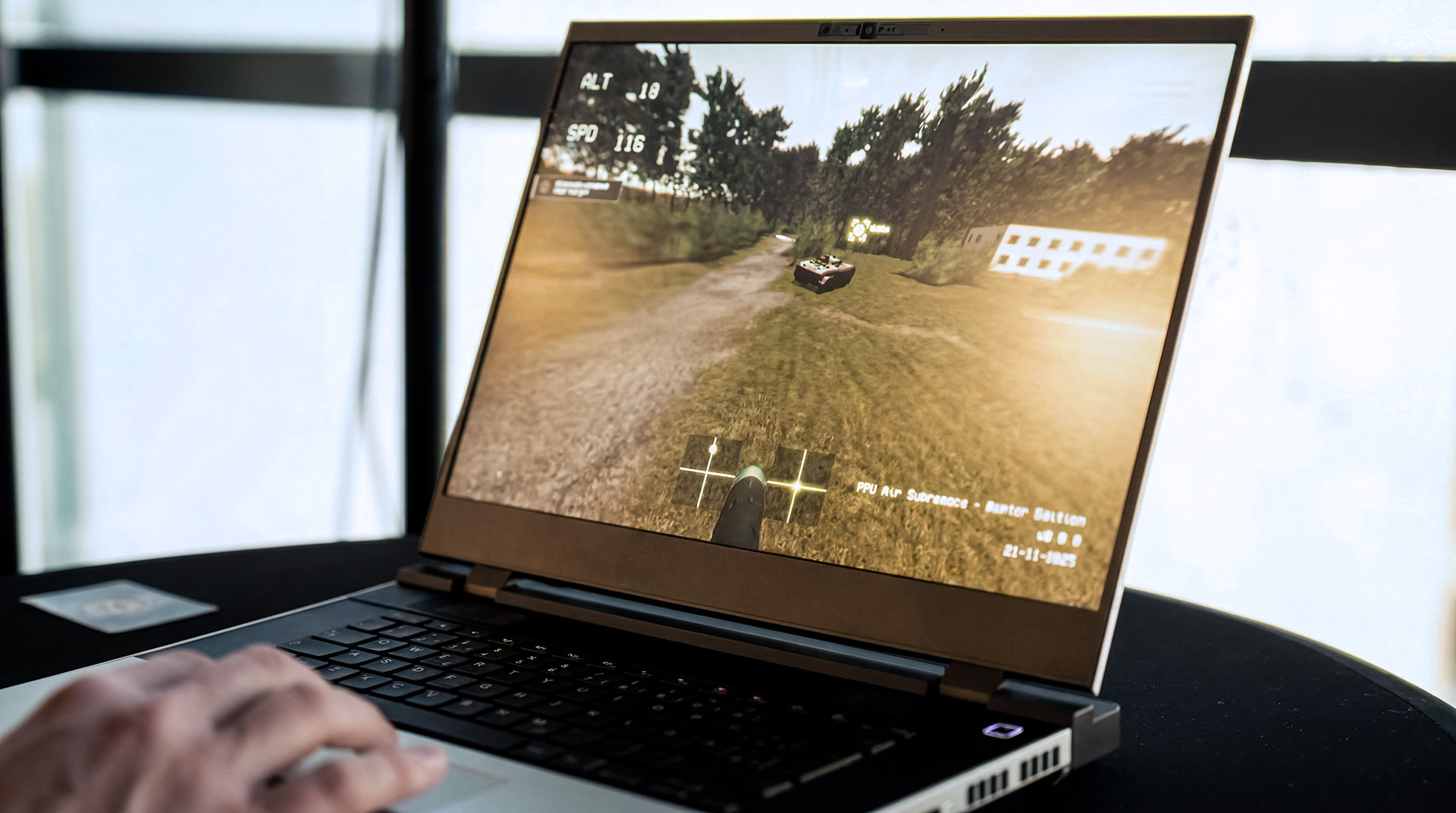 Laptop zeigt militärische Simulationsszene mit Fahrzeug