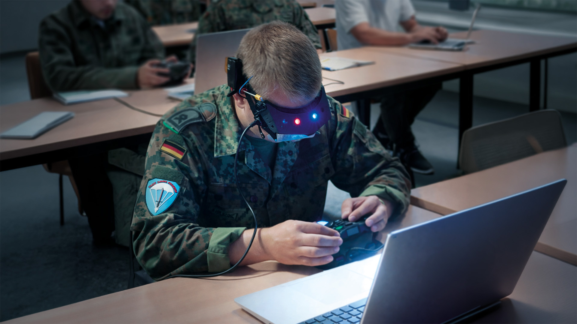 Teilnehmende arbeiten mit VR-Brille und Laptop im Schulungsraum