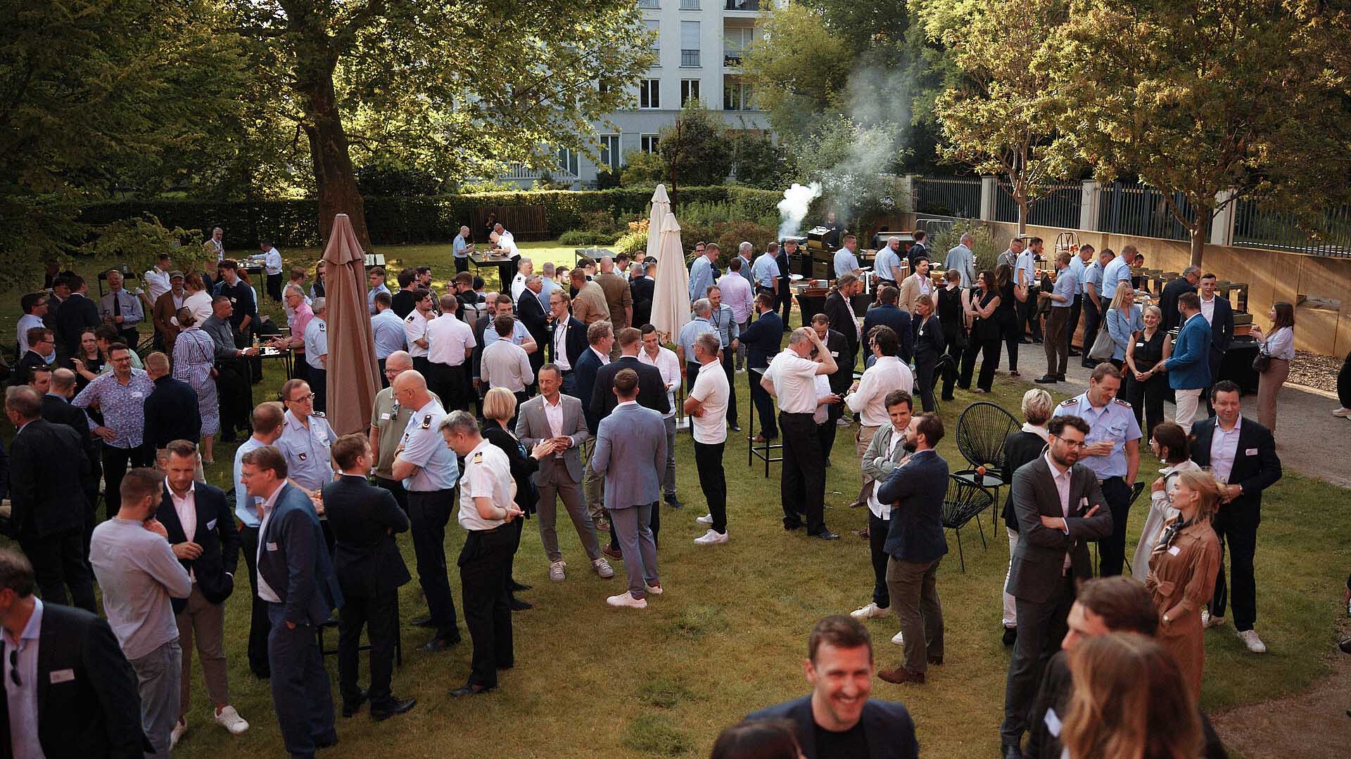 Große Gruppe von Teilnehmenden im Austausch auf dem Sommerfest