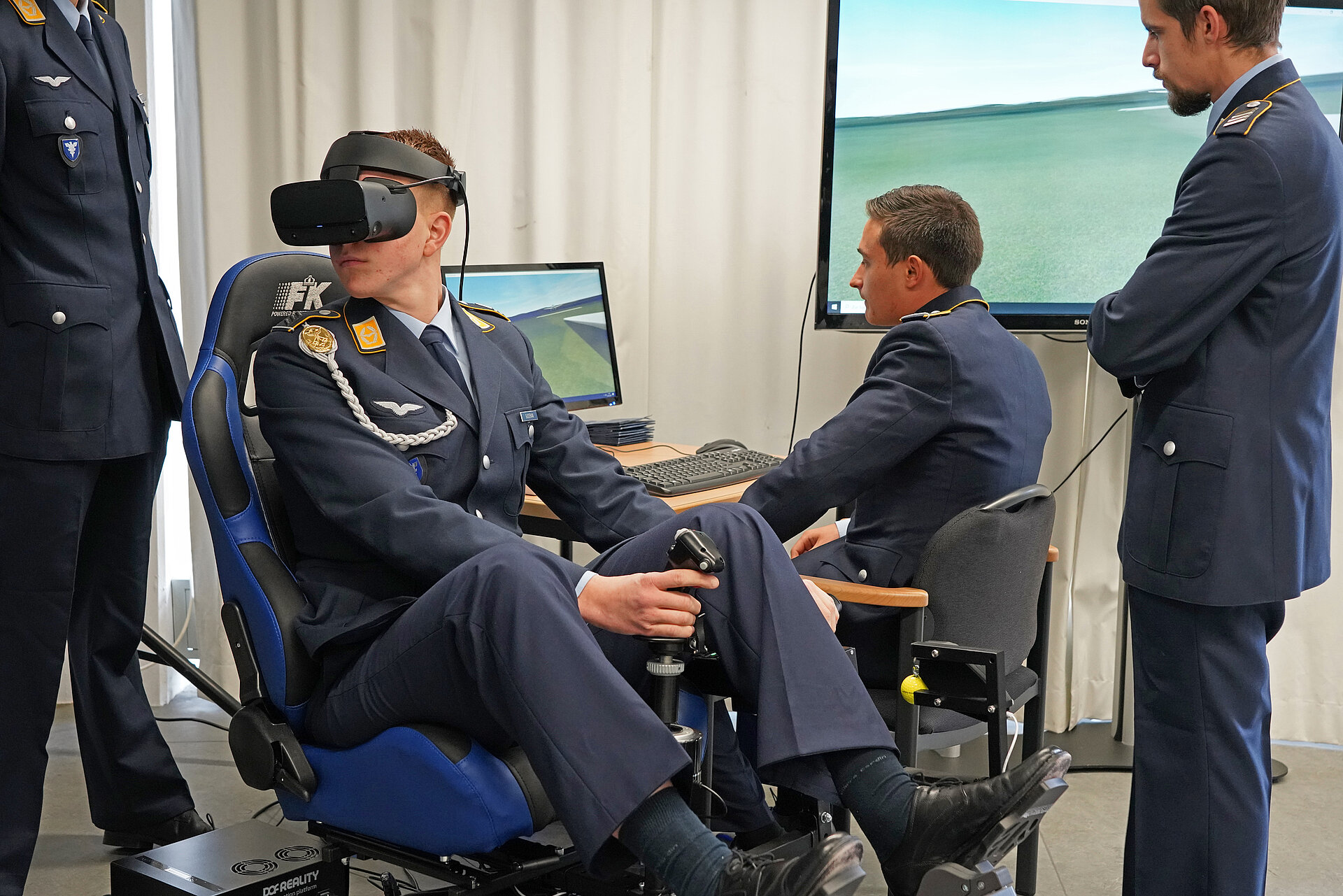 Ein Soldat sitzt im Stuhl des VR-Segelflugsimulators und fliegt.