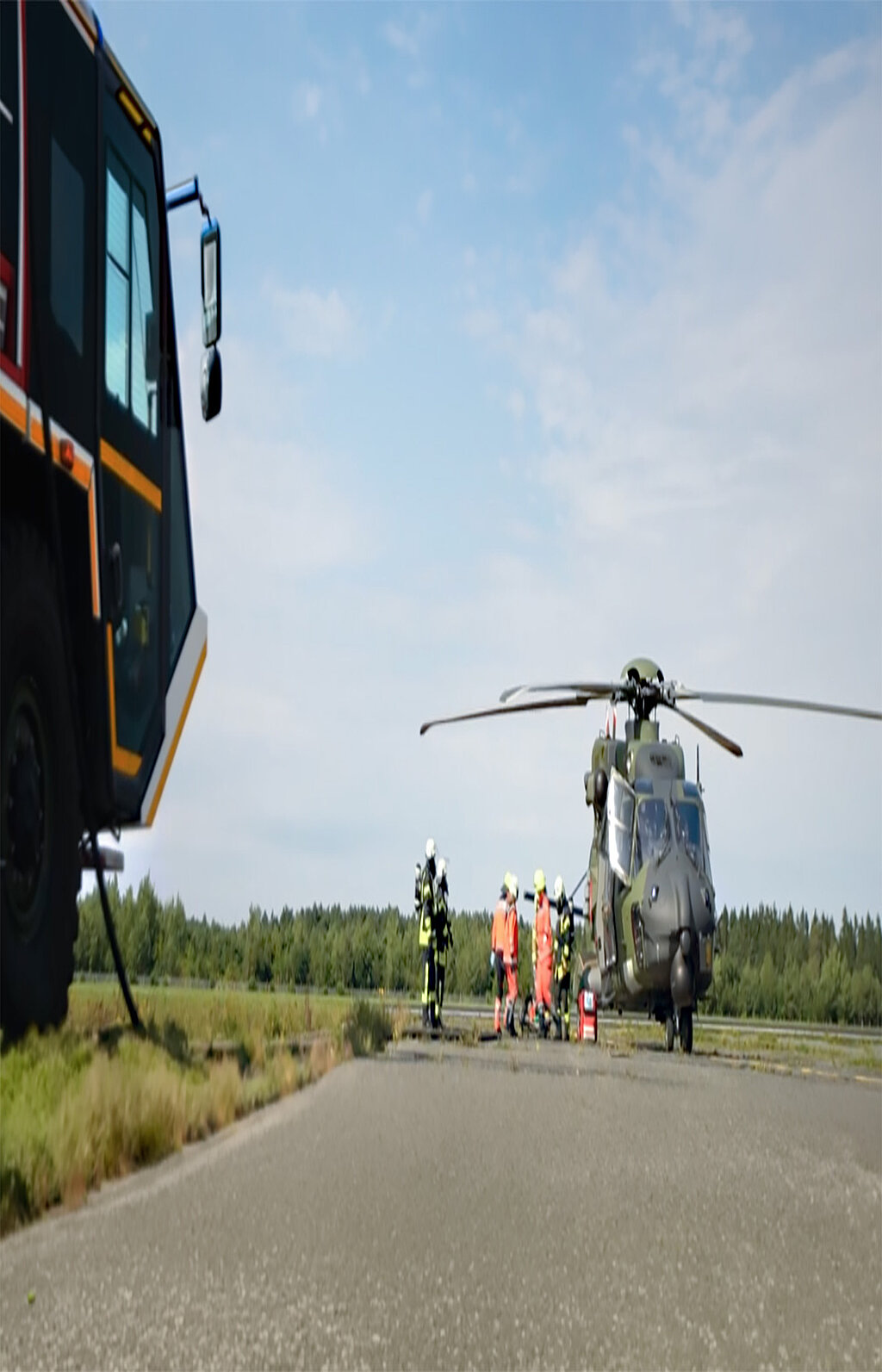 Rettungsteam arbeitet neben Hubschrauber und Einsatzfahrzeug auf Landebahn
