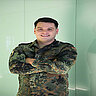 Leutnant Christopher steht in Uniform mit verschränkten Armen vor hellem Hintergrund