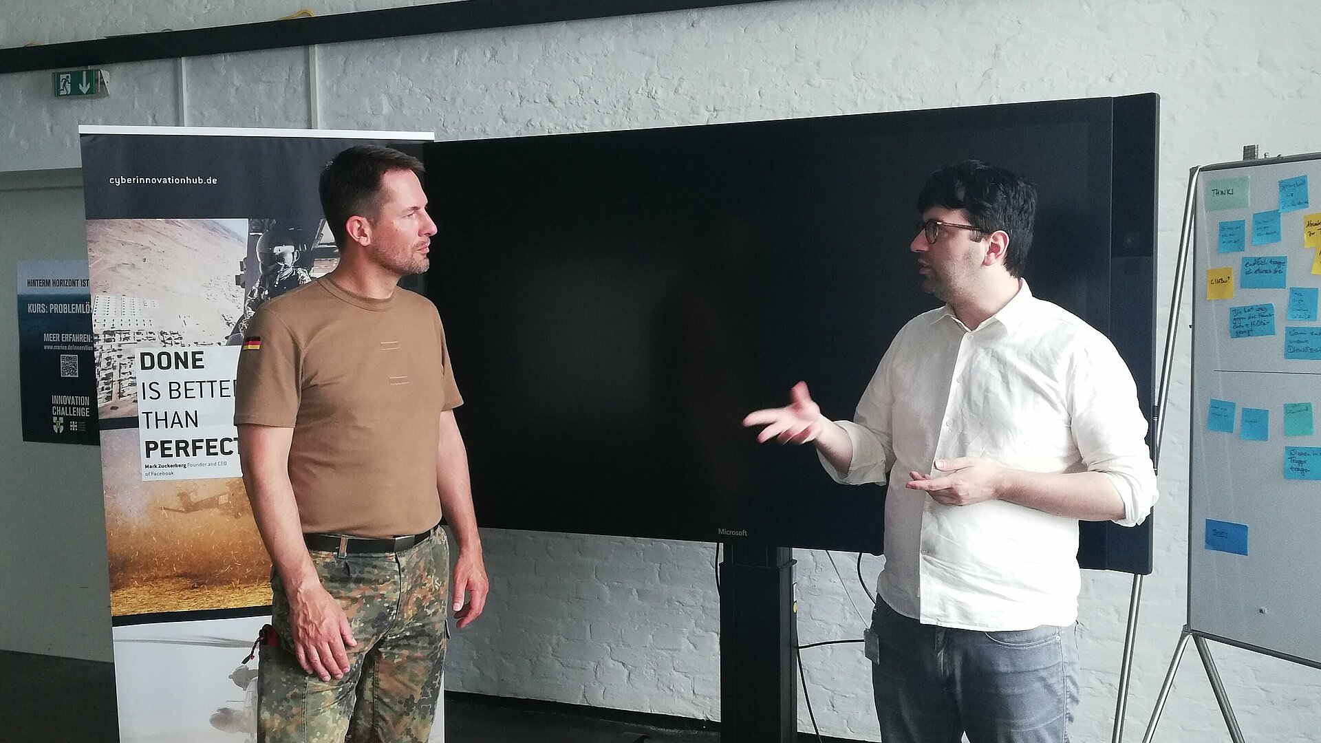 Zwei Männer stehen in einem Raum und unterhalten sich.