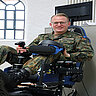 Oberleutnant Hubertus sitzt auf Trainingsgerät und hält Virtual-Reality-Brille