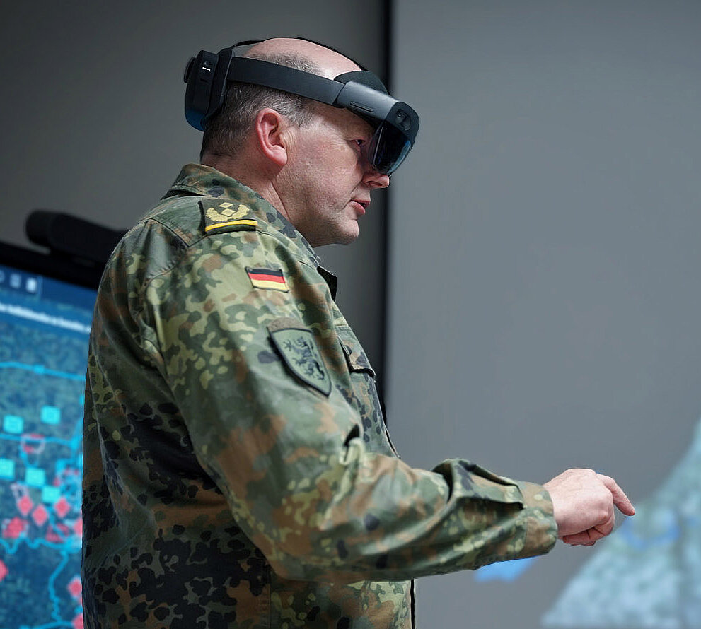 Soldat nutzt Mixed-Reality-Brille vor digitaler Kartenansicht