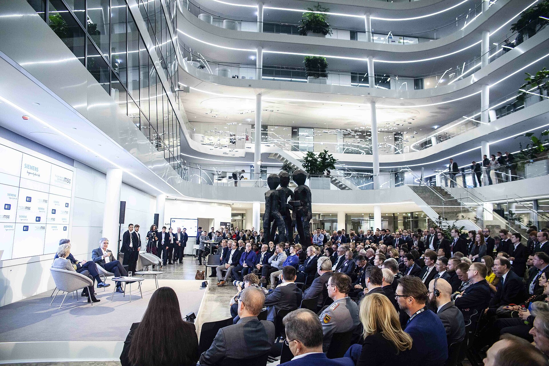 Siemens Headquarter mit Gästen der MSC Innovation Night 2019 und drei Speakern auf dem Podium.