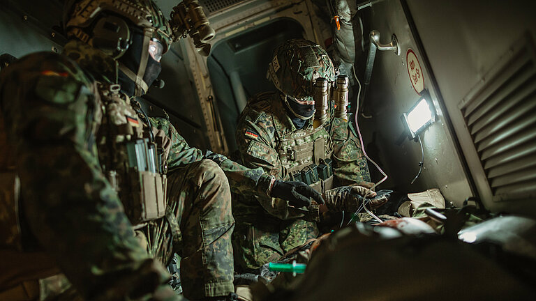 Zwei uniformierte Soldaten bei einem medizinischen Einsatz