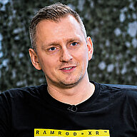 Paul Kaden sitzt vor Monitoren mit technischer Anzeige im Hintergrund