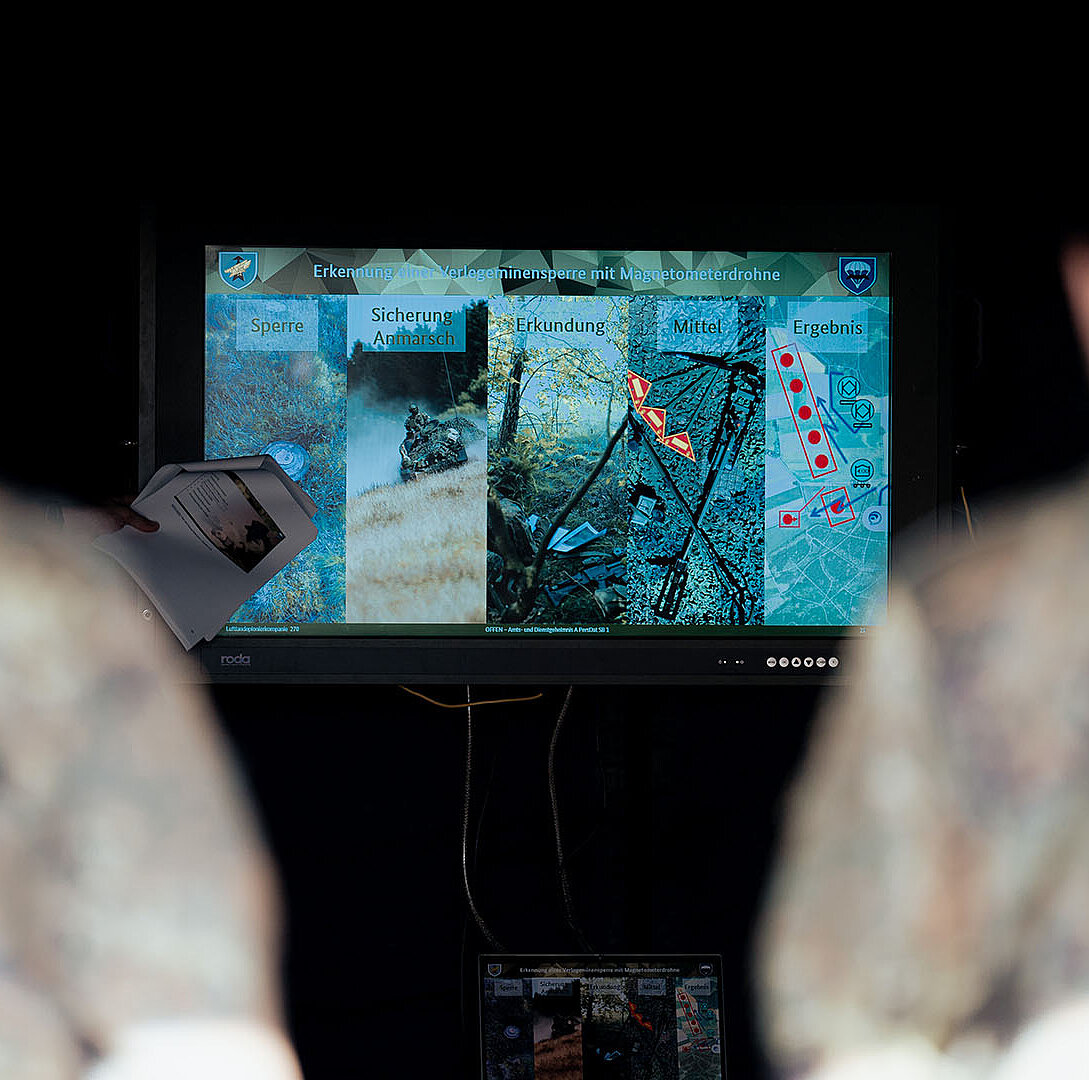 Zwei Personen betrachten Analysefolie auf Monitor im Innenraum
