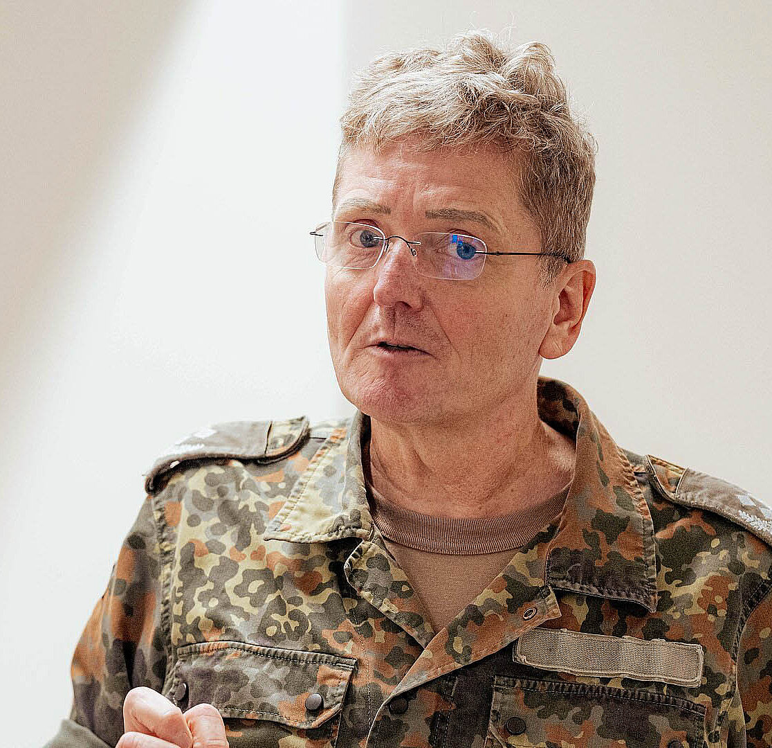 Person in Uniform spricht mit anderer Person im Innenraum