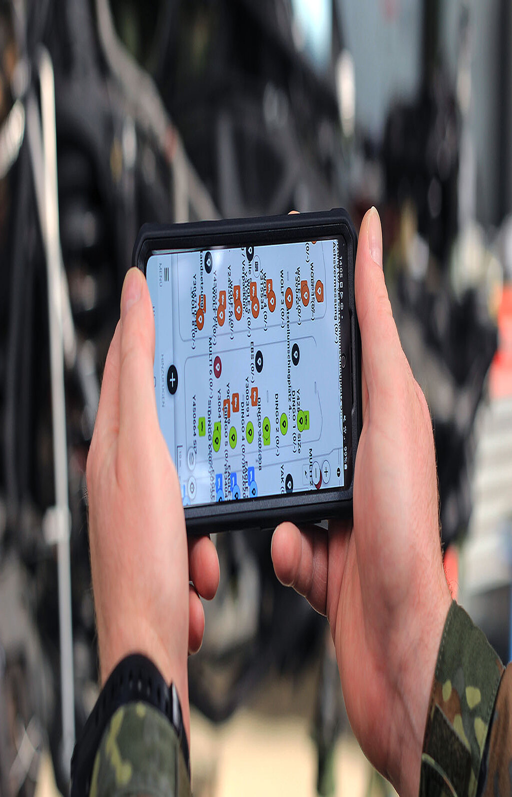 Hände halten Smartphone mit technischer Übersicht auf dem Display