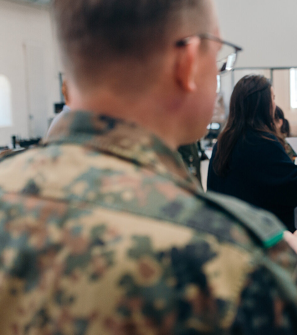 Gespräch zwischen Zivilperson und Soldat in Workshop-Umgebung