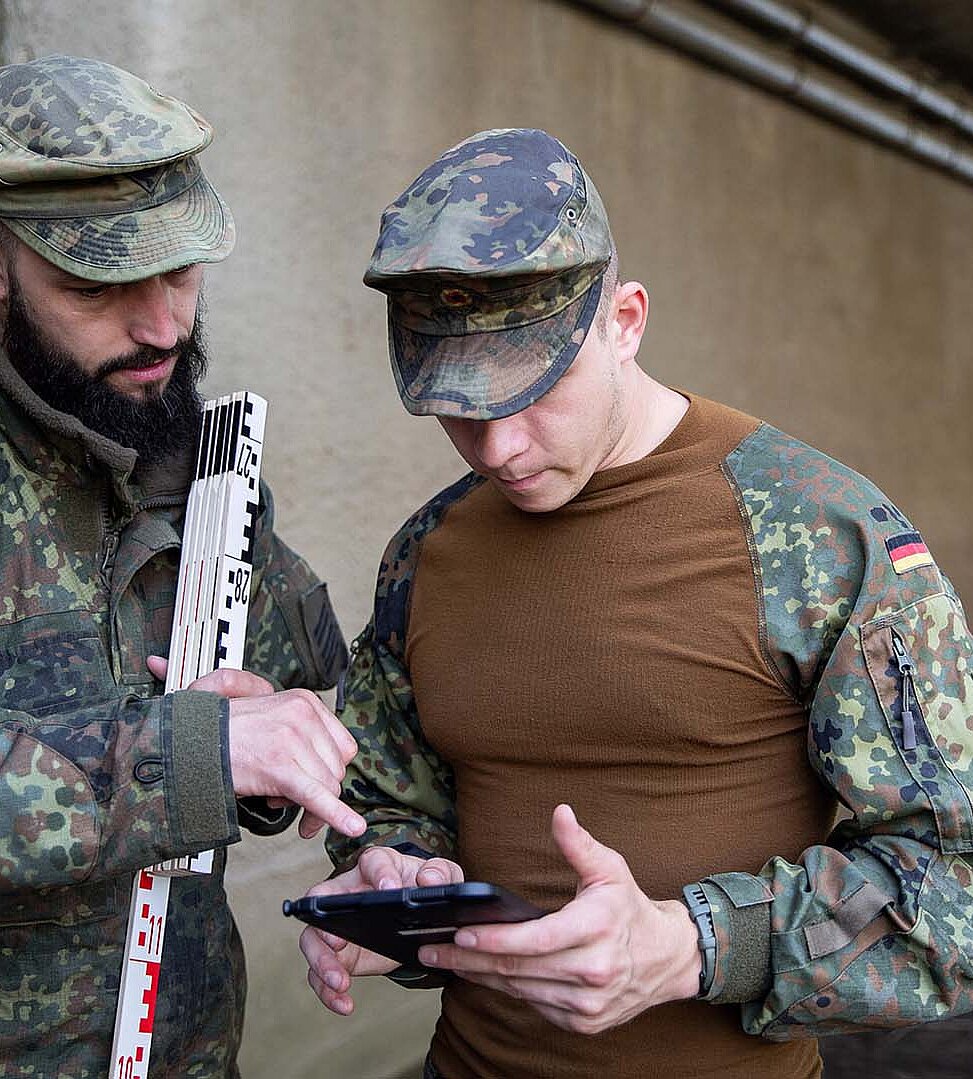 Soldaten schauen gemeinsam auf Tablet
