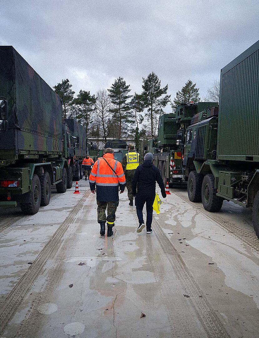 Soldaten laufen zwischen Fahrzeugen