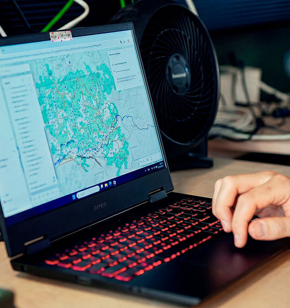 Laptop zeigt digitale Karte mit markierten Geländedaten