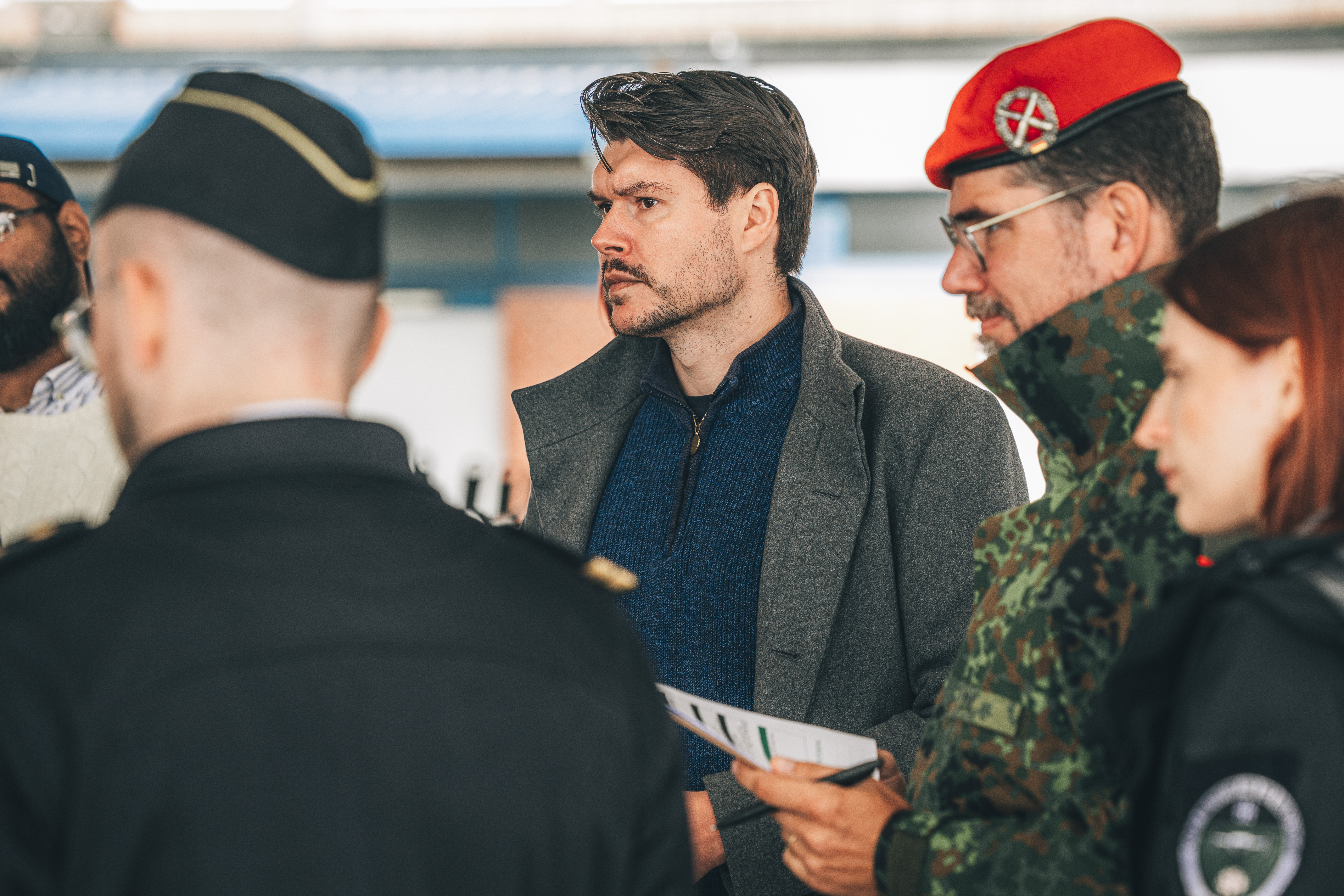 Menschengruppe mit einem Marinesoldaten von hinten, daneben ein Bundeswehrsoldat mit rotem Barett und drei zivile Mitarbeitende des CIHBw.
